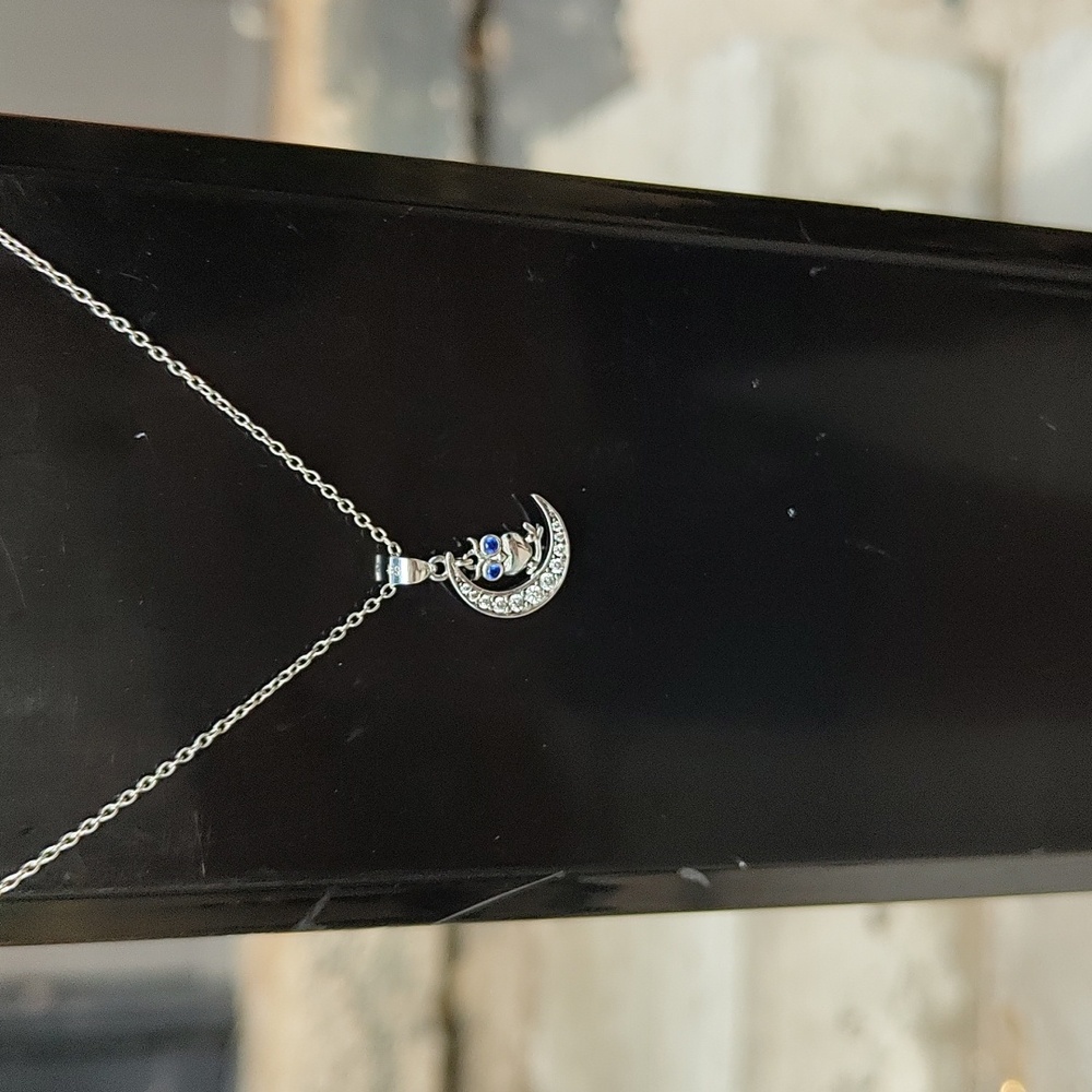 925 stamped dangly owl necklace with blue eyes sitting on a moon